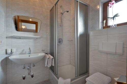 uma casa de banho com um chuveiro e um lavatório. em Apartments Steindlhof em Schwendau