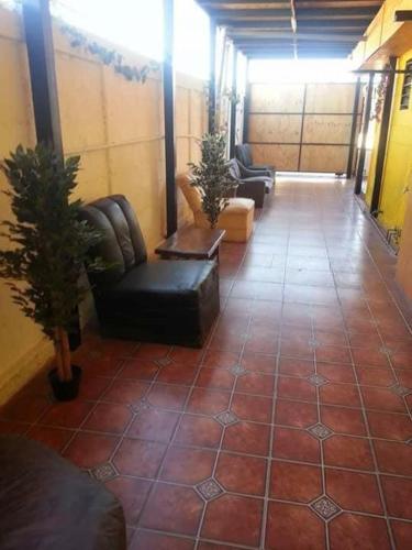 a lobby with couches and chairs on a tile floor at Hostel Chango in Caldera