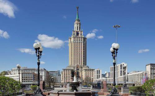 ein großes Gebäude mit einem hohen Turm in einer Stadt in der Unterkunft Hilton Moscow Leningradskaya in Moskau