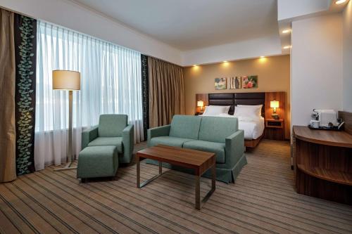 une chambre d'hôtel avec un lit, deux chaises et une table dans l'établissement Hilton Garden Inn Novorossiysk, à Novorossiisk