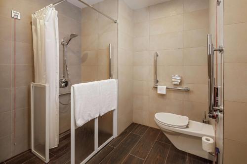 a bathroom with a toilet and a shower at Hilton Garden Inn Novorossiysk in Novorossiysk
