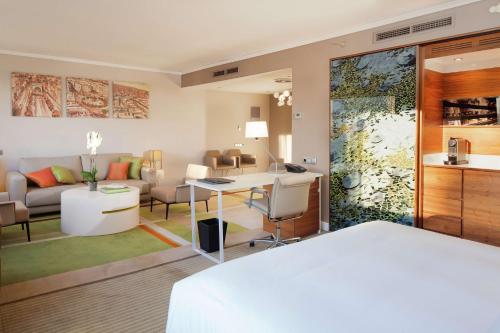 a bedroom with a bed and a living room at Hilton Barcelona in Barcelona