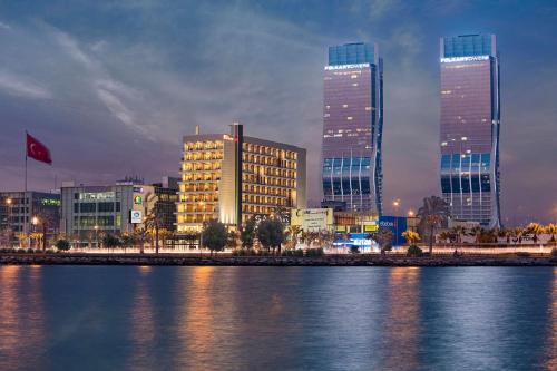 a city with tall buildings and a river at night at Hilton Garden Inn Izmir Bayrakli in Izmir