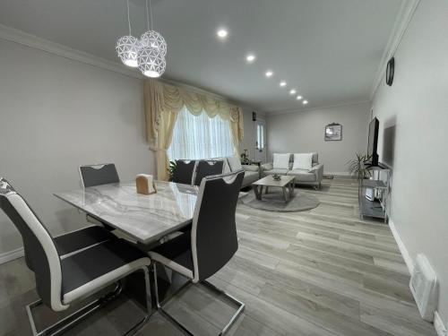 a dining room and living room with a table and chairs at Luxurious Cozy House in Bluffs with Lake View in Toronto
