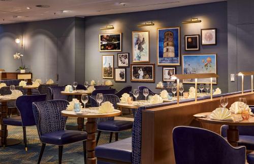 a restaurant with tables and chairs and pictures on the wall at Hilton Düsseldorf in Düsseldorf
