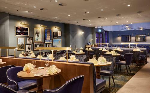 a restaurant with tables and chairs and a bar at Hilton Düsseldorf in Düsseldorf
