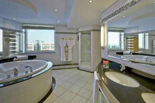 a large bathroom with two sinks and a tub at Hilton Düsseldorf in Düsseldorf
