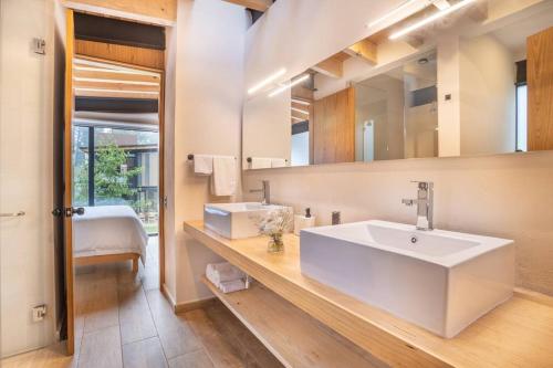 La salle de bains est pourvue d'un lavabo blanc et d'un miroir. dans l'établissement CASA NUEVA en Avandaro rodeada de Naturaleza, à Valle de Bravo