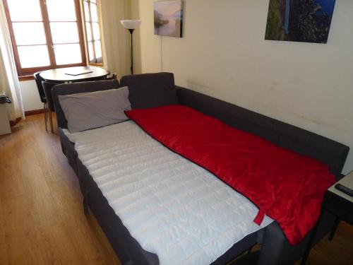 1 Bedroom Flat in Historic Cooperage Apartments Leith في إدنبرة: سرير عليه بطانية حمراء في الغرفة