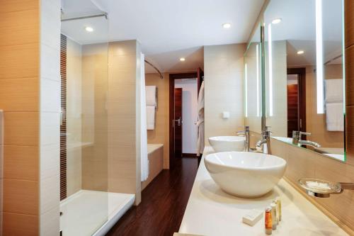 a large bathroom with two sinks and a shower at Hilton Garden Inn Krasnodar in Krasnodar