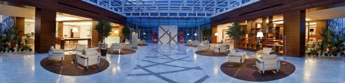 a lobby with chairs and tables in a building at Hilton Garden Inn Konya in Konya