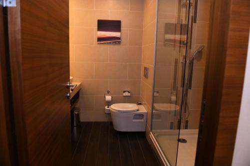 uma casa de banho com um WC e uma cabina de duche em vidro. em Hilton Garden Inn Konya em Konya