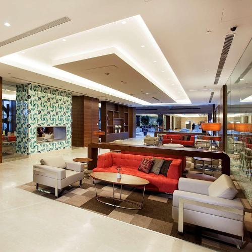 a living room with a red couch and chairs at Hilton Garden Inn Konya in Konya