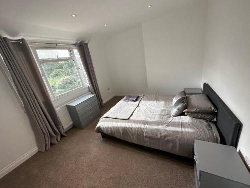 um quarto com uma cama e uma grande janela em 3 bedroom house Maidstone em Maidstone