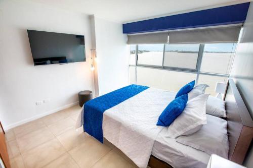 - une chambre avec un lit doté d'oreillers bleus et d'une fenêtre dans l'établissement Hermosa suite vista al rio 306, à Guayaquil