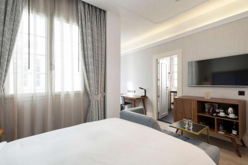 a hotel room with a bed and a television at DoubleTree by Hilton Madrid-Prado in Madrid