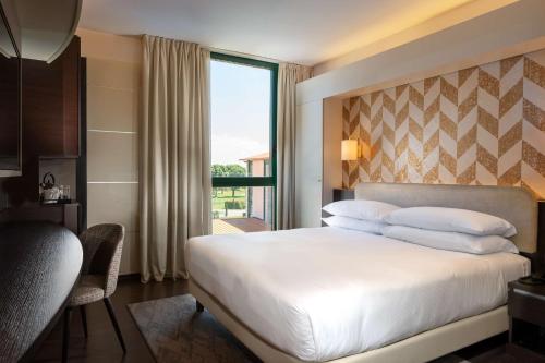 a hotel room with a large bed and a window at Doubletree by Hilton Milan Malpensa Solbiate Olona in Solbiate Olona