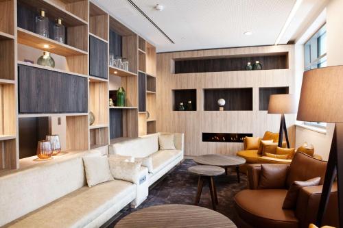 a living room with a couch and a table at Hampton By Hilton Dortmund Phoenix See in Dortmund
