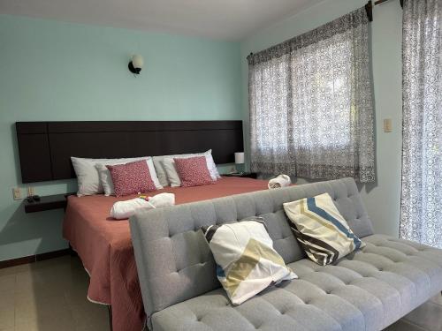 un soggiorno con un divano e un letto di LA VILLA DE LA ABUELA a San Cristóbal de Las Casas