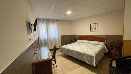 Un dormitorio con una cama y una mesa. en Domus Viatoris, en Sahagún