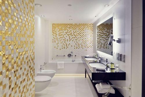 ein Badezimmer mit 2 Waschbecken und 2 WCs in der Unterkunft DoubleTree by Hilton Łódź in Łódź