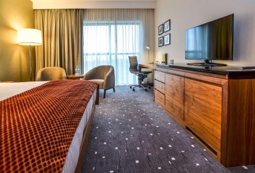 a hotel room with a bed and a flat screen tv at DoubleTree by Hilton Łódź in Łódź