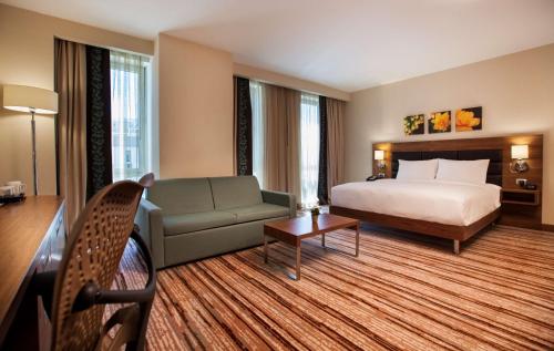 une chambre d'hôtel avec un lit et un canapé dans l'établissement Hilton Garden Inn Erzincan, à Erzincan