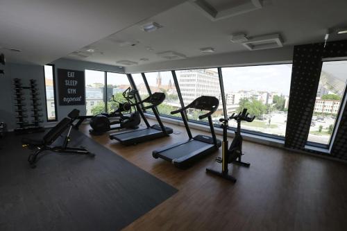 a gym with several tread machines in a room with windows at Hampton By Hilton Olsztyn in Olsztyn