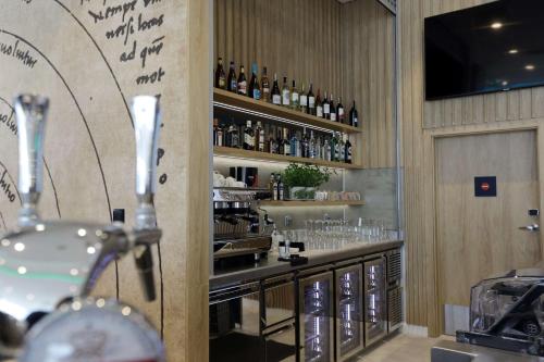a bar with bottles and glasses on the wall at Hampton By Hilton Olsztyn in Olsztyn