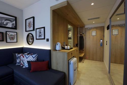 a living room with a couch and a kitchen at Hampton By Hilton Olsztyn in Olsztyn