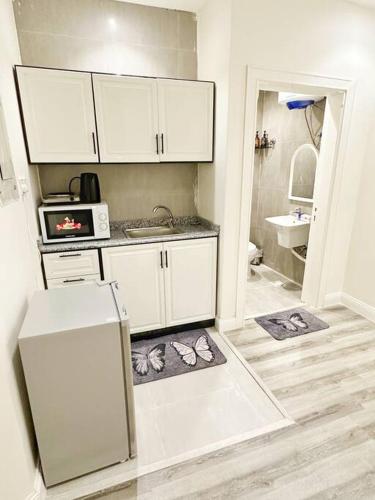 a kitchen with white cabinets and a white refrigerator at شقة جميلة، دخول ذاتي ٢٠١ in Riyadh