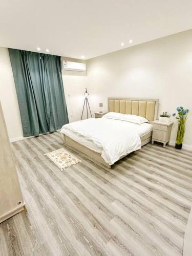 1 dormitorio con 1 cama grande y suelo de madera en Luxury Apartment 201, en Riad