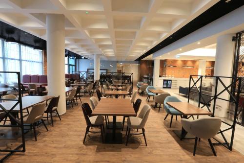 - un restaurant avec des tables et des chaises dans une salle dans l'établissement Hampton By Hilton Gdansk Old Town, à Gdańsk