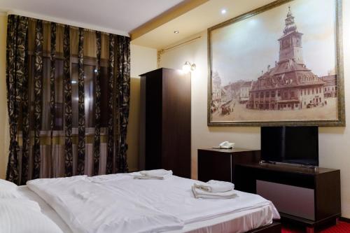 a hotel room with a bed and a picture of a building at Complex Turistic Max International in Râşnov