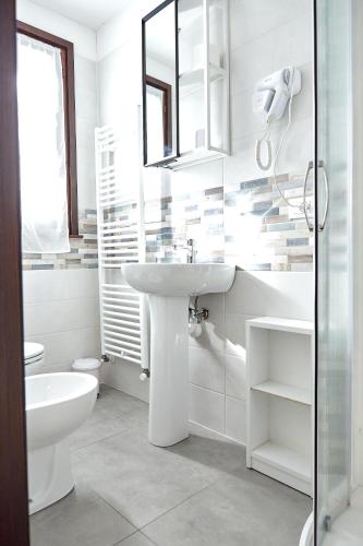 a white bathroom with a sink and a toilet at Agriturismo La Foscarina in Vescovana
