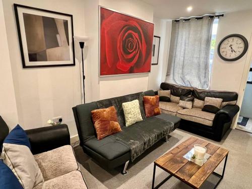 a living room with two couches and a table at 4 Bedroom Terrace house Near Town Center Wellingborough in Wellingborough