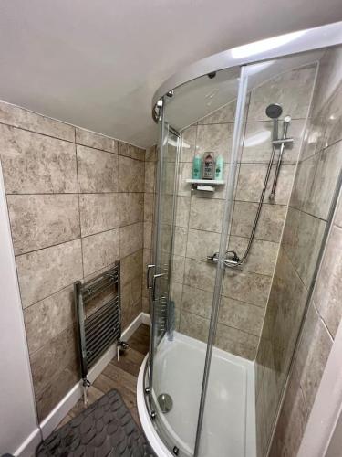 a bathroom with a shower with a glass door at 4 Bedroom Terrace house Near Town Center Wellingborough in Wellingborough