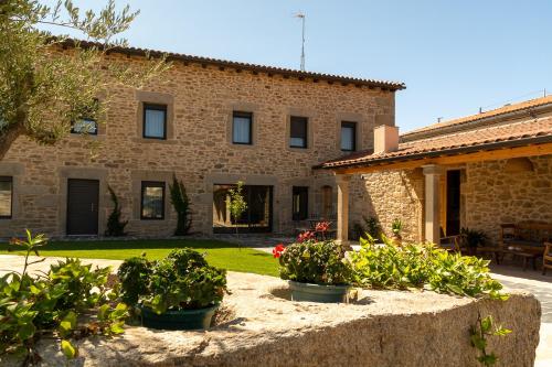 a stone house with potted plants in front of it at LA ALCOBA DE SAYAGO in Bermillo de Sayago