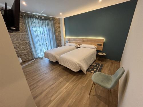 a bedroom with a bed and a chair at LA ALCOBA DE SAYAGO in Bermillo de Sayago