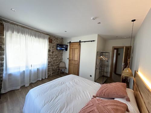 a bedroom with a white bed and a window at LA ALCOBA DE SAYAGO in Bermillo de Sayago