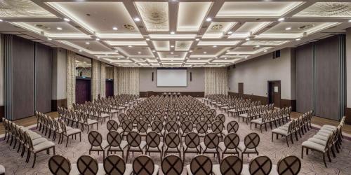an empty room with rows of chairs and a projection screen at Hilton Podgorica Crna Gora in Podgorica