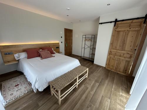 a bedroom with a large bed and a wooden door at LA ALCOBA DE SAYAGO in Bermillo de Sayago