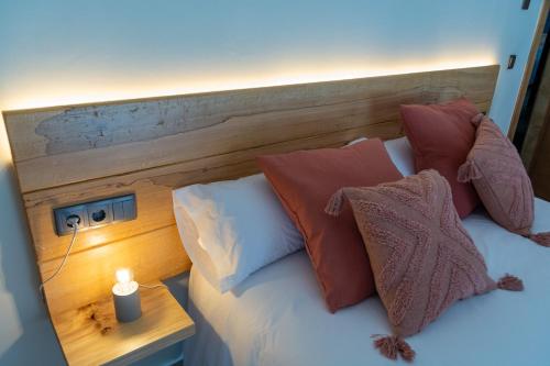 a bed with pillows and a candle on a table at LA ALCOBA DE SAYAGO in Bermillo de Sayago
