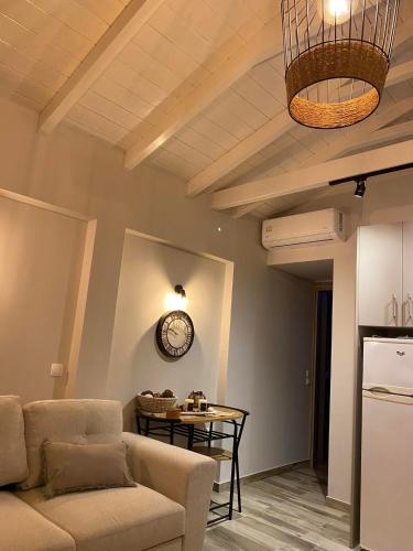 a living room with a couch and a clock on the wall at Ζωή Apartment in Preveza