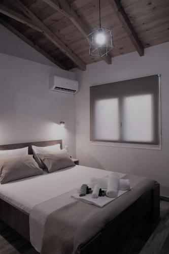 a white bedroom with a large bed with a window at Ζωή Apartment in Preveza