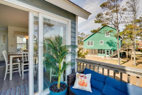 a blue couch on a porch with a table and a house at Hot Tub, Pirate Fort and Fire Pit Outer Banks Home! in Nags Head