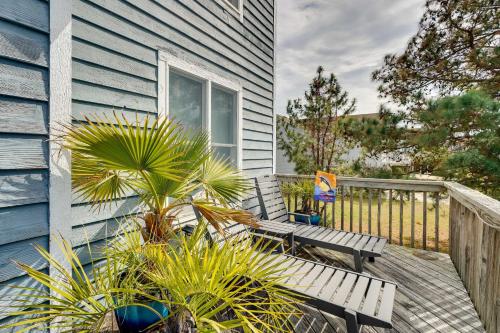 a blue house with a bench on a deck at Hot Tub, Pirate Fort and Fire Pit Outer Banks Home! in Nags Head