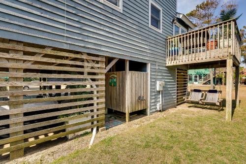 a house with a wooden fence and a balcony at Hot Tub, Pirate Fort and Fire Pit Outer Banks Home! in Nags Head