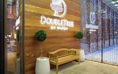 a store front with a bench in front of a building at DoubleTree by Hilton Moscow – Marina in Moscow