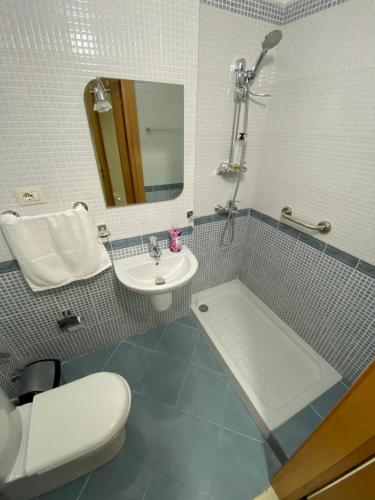uma casa de banho com um lavatório, um WC e uma banheira em Premier by Broci Apartments em Tirana